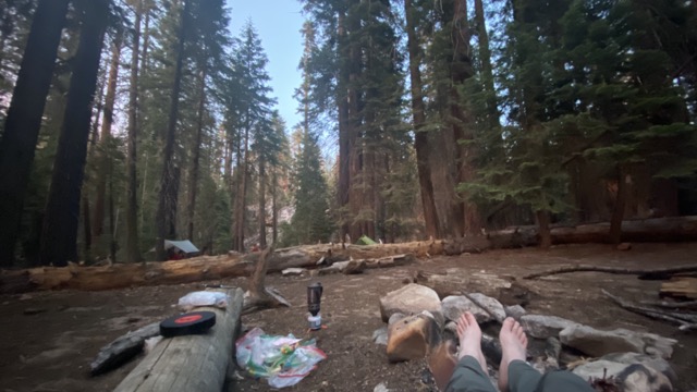 James warming his feet by the dying embers before bedding down for the night.